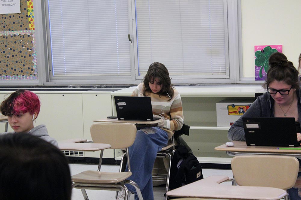 HS female working on a chromebook at her desk