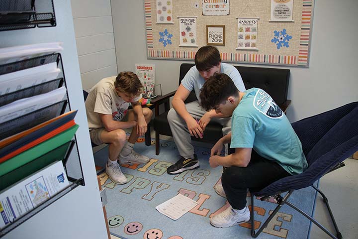 students sitting in counseling office trying to figure out brain teaser