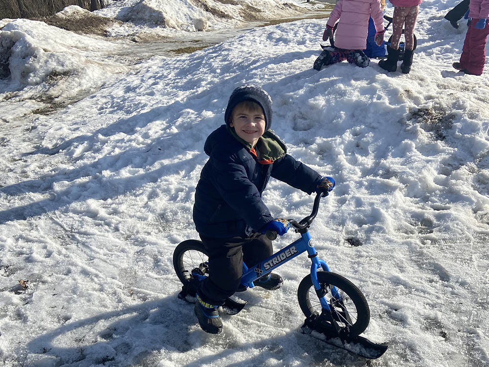 Student Smiling on a Snow Bike