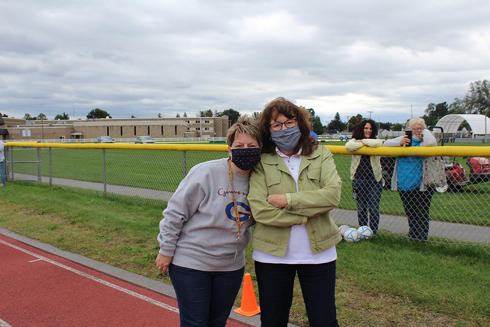 two female teachers posing for picture on the track during the pep rally