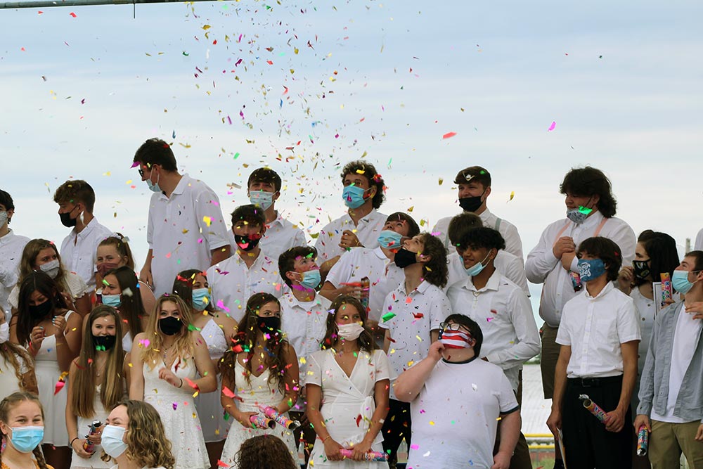 class of 2021 students on stage at moving up day with confetti poppers