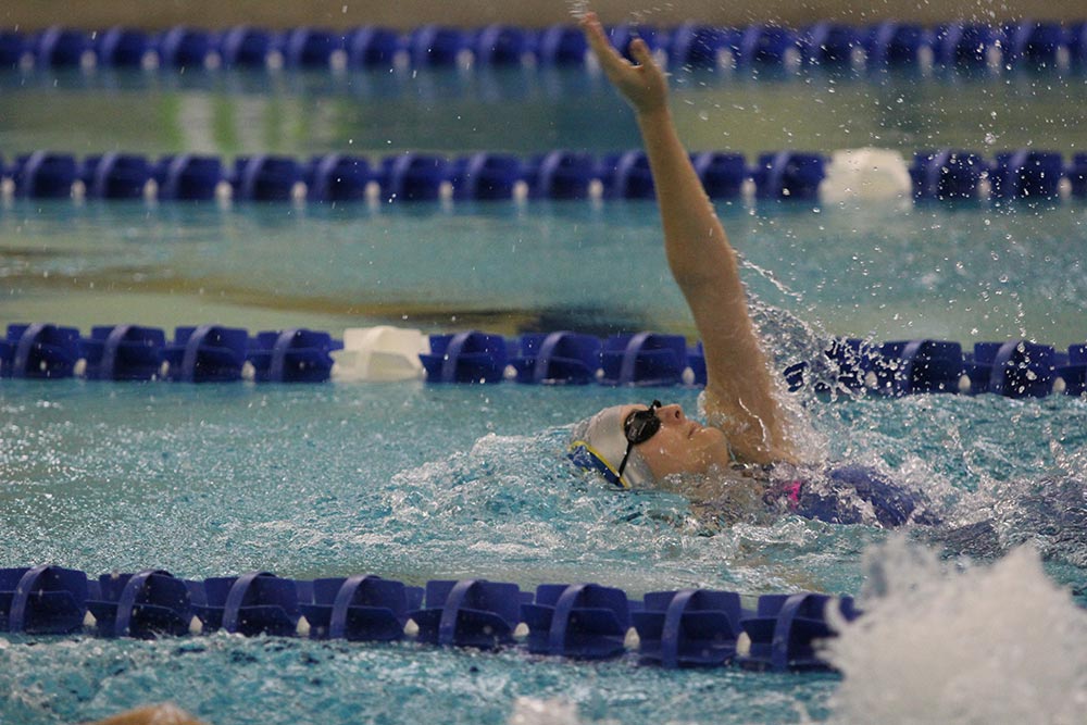varsity girl doing the backstroke in competition