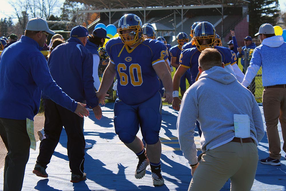 football coaches greeting their team members as they enter the field before a game