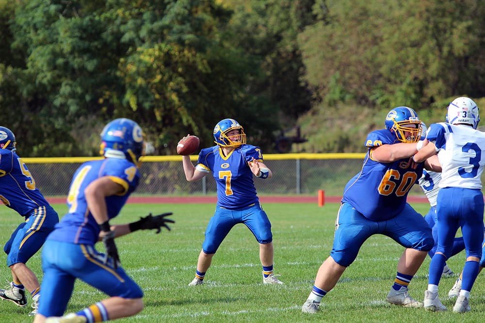 Varsity football quarterback in mid-throw