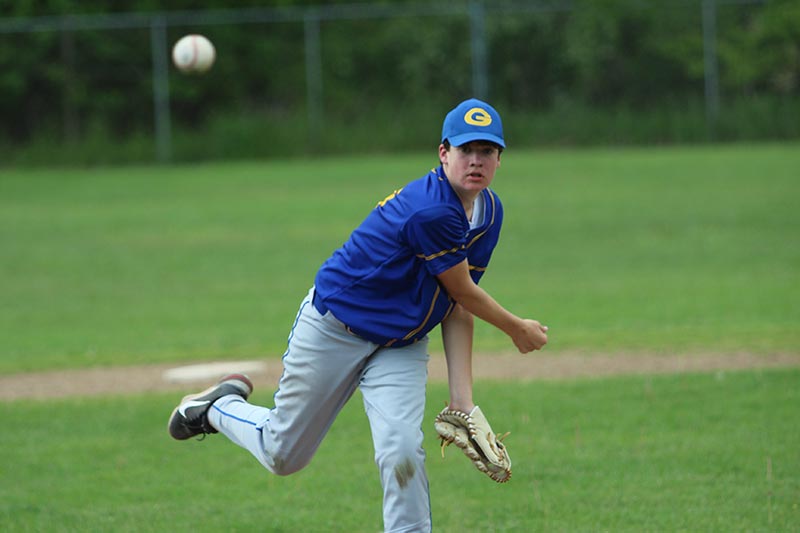 varsity baseball pitcher on the mound throwing ball