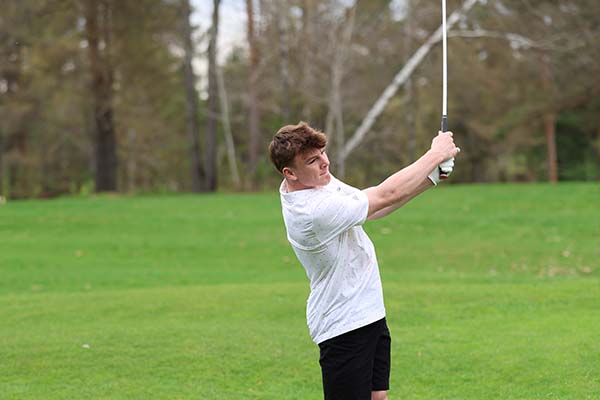 varsity golfer at end of his swing