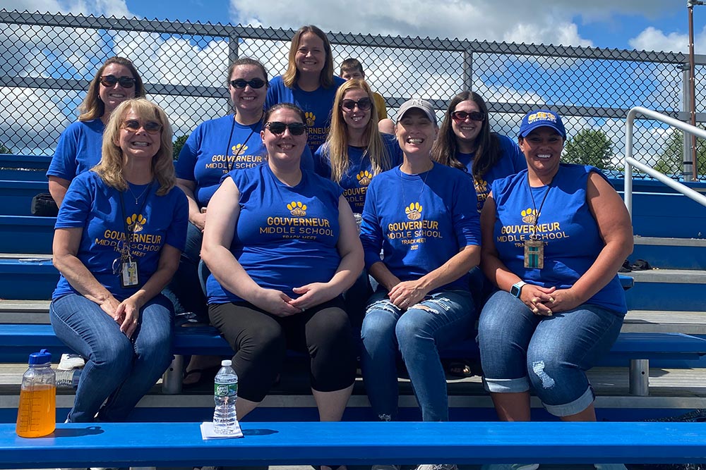 middle school teachers posing on the football bleachers