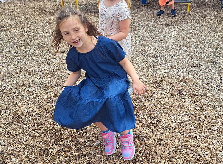 student jumping around on playground