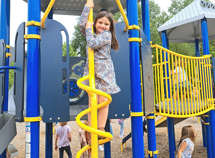 student on spiral pole at the playground