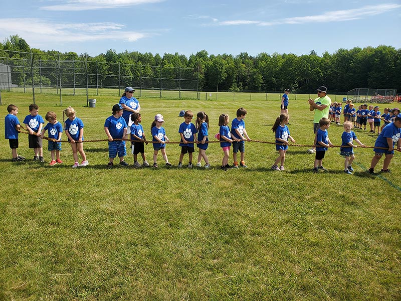 elementary students holding onto rope waiting for tug of war to start