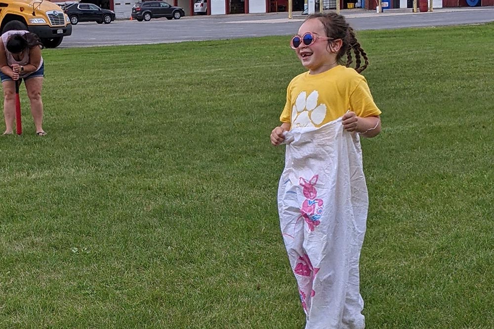 elementary girl jumping in a potato sack race