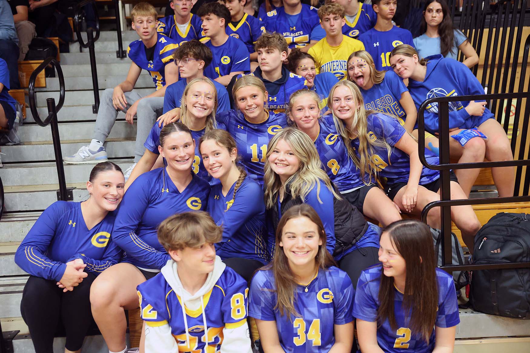 students at pep rally on bleachers dressed in their uniforms