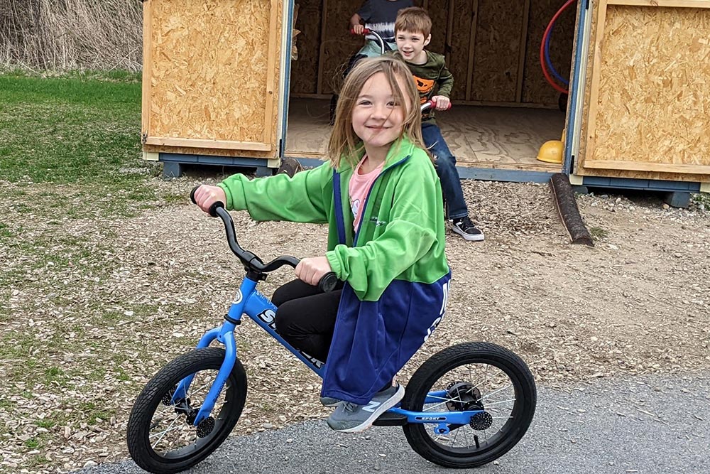 Elementary students riding bikes on the pavement